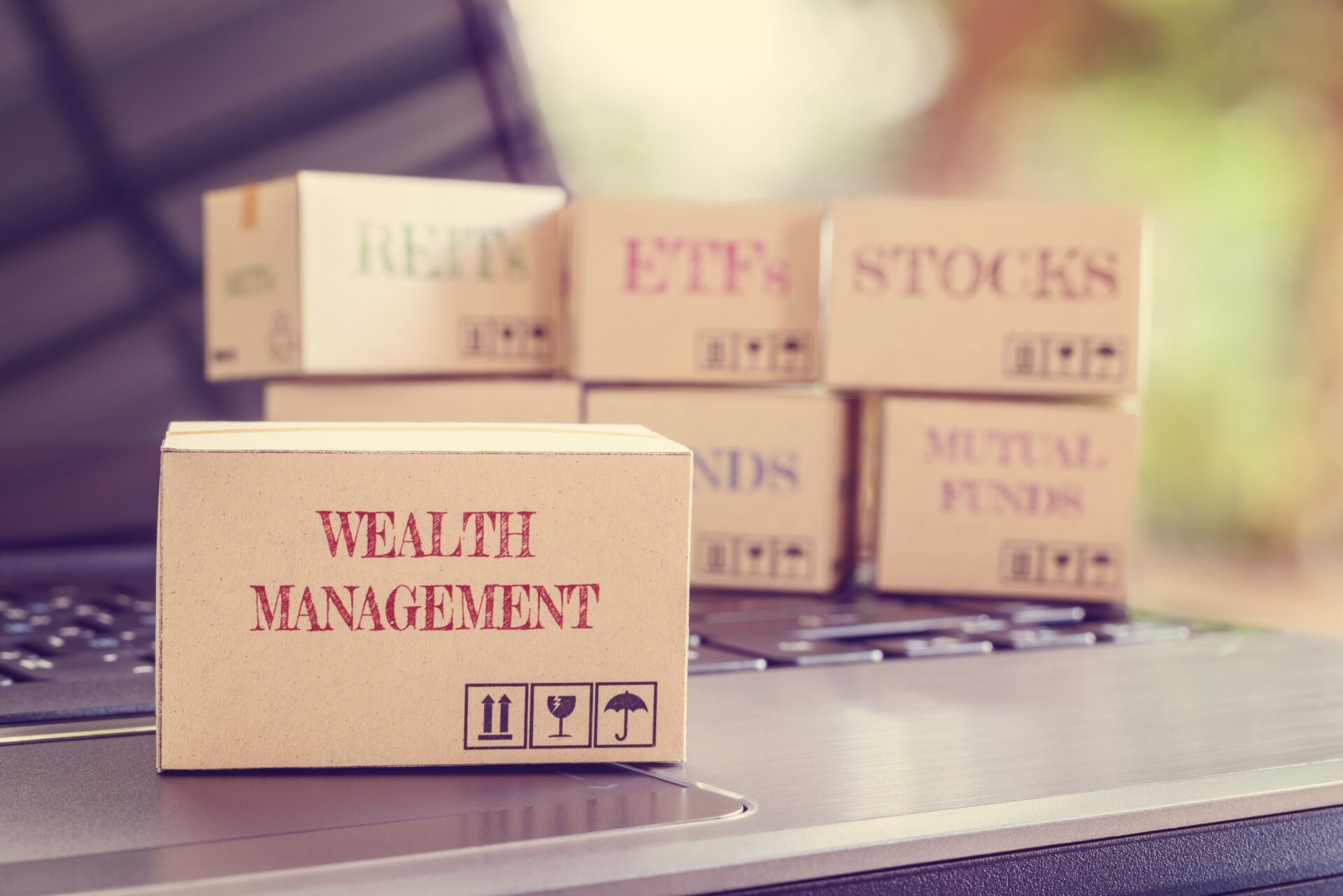 Boxes of financial products e.g REITs, bonds, commodities, mutual funds, stocks, ETFs on a laptop